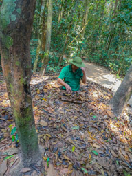 2 of 4:  He has moved the lid and is standing in the tunnel.  He puts leaves over the lid for the camouflage.
