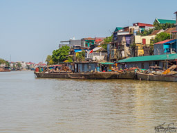 Much activity along the river, with houses right up to the edge.