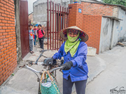 Young woman and some kids watch us as we walk through the village.
