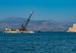 Waiting for our boat ride around Nafplion and watching two hugh machines work on deepining the harbor.